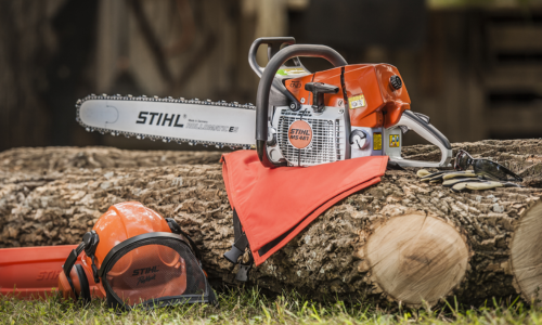 A Stihl chainsaw resting on a fell tree.